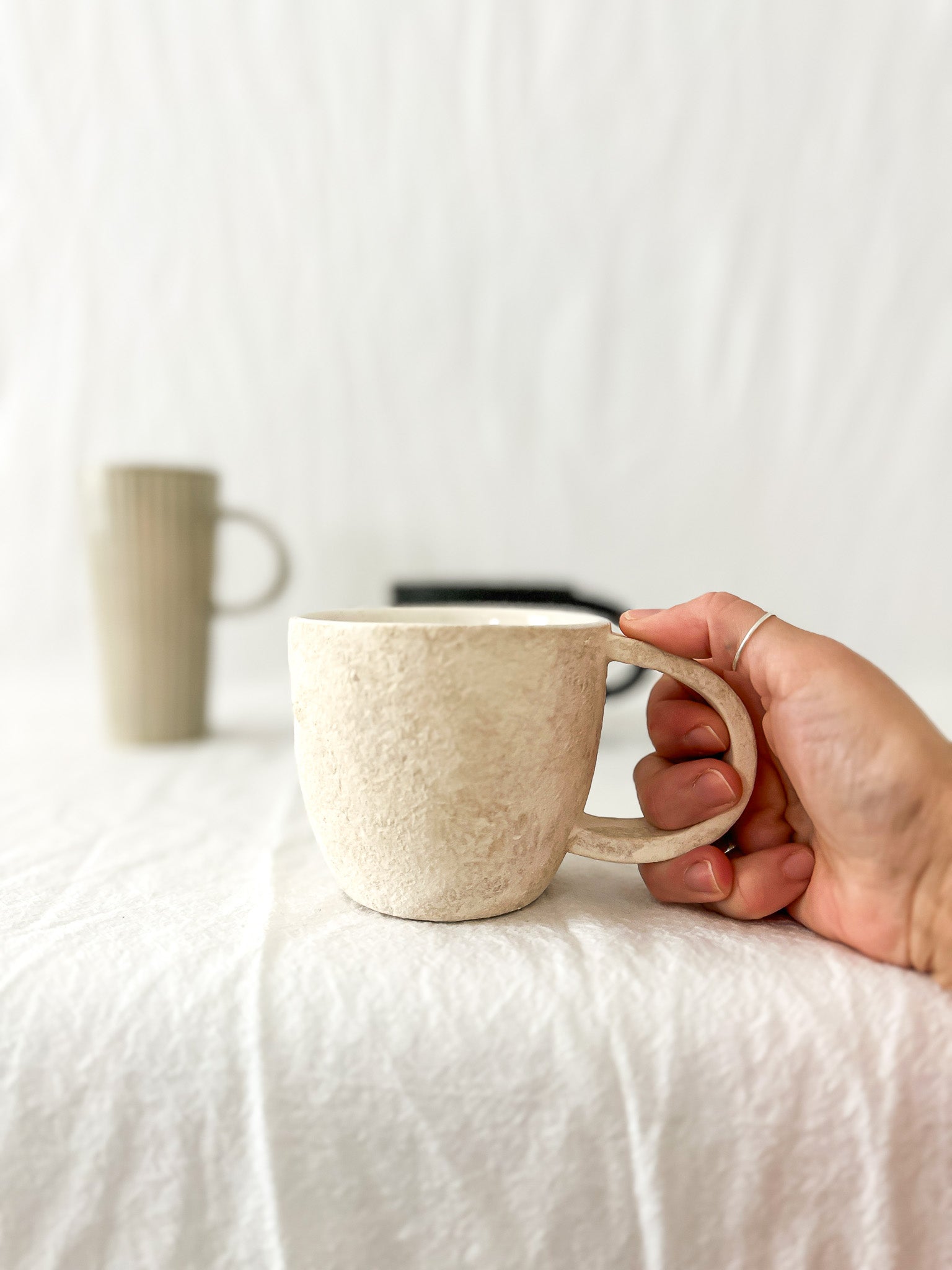 Assorted handmade ceramic mugs with textured glazes, dishwasher-safe seconds-sale pieces from Muddy Heart