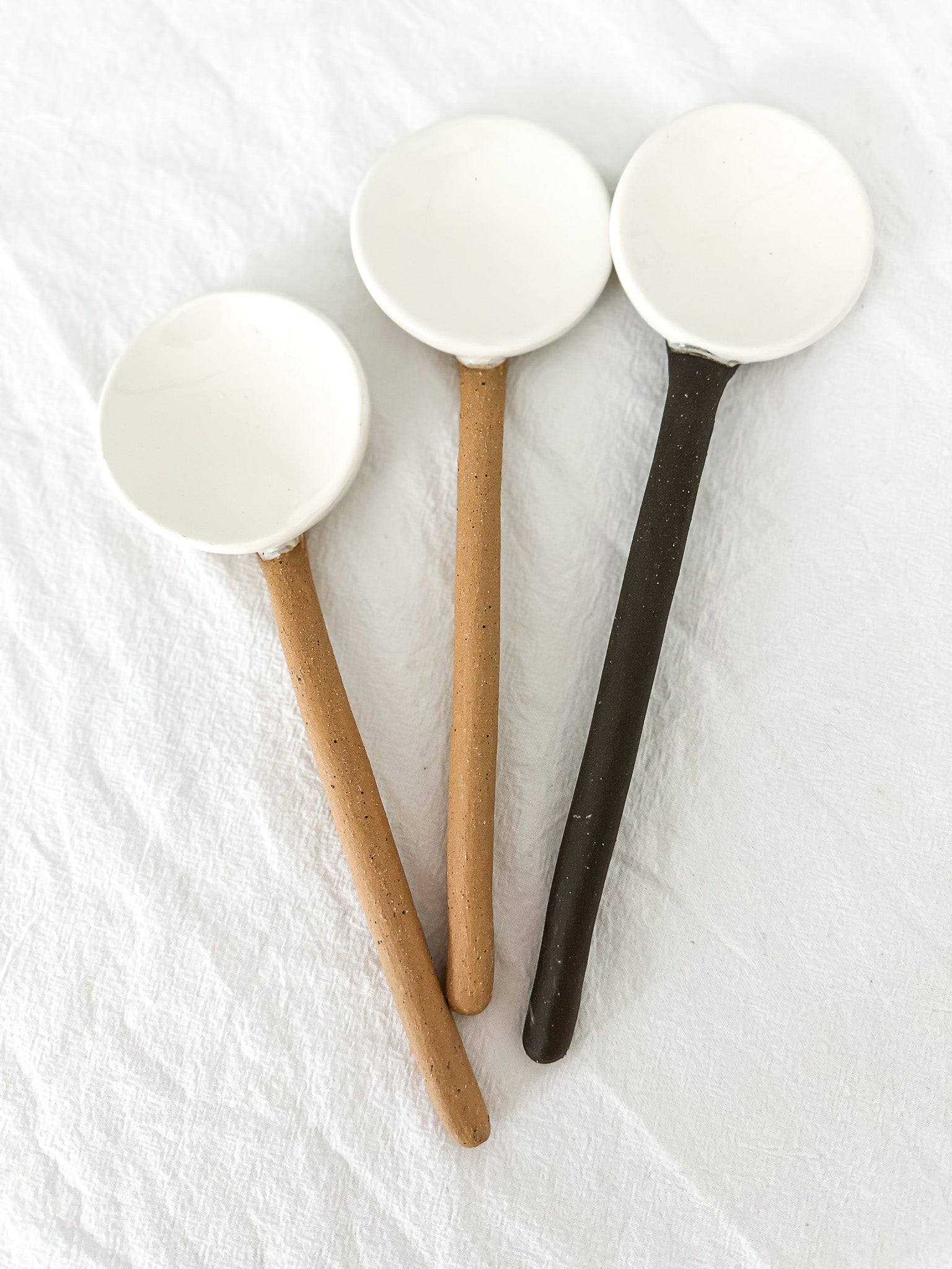 Handmade ceramic coffee and spice spoons in buff and espresso glazes, seconds-sale pieces from Muddy Heart