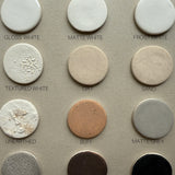 Muddy Heart glaze samples chart showing twelve neutral ceramic finishes.