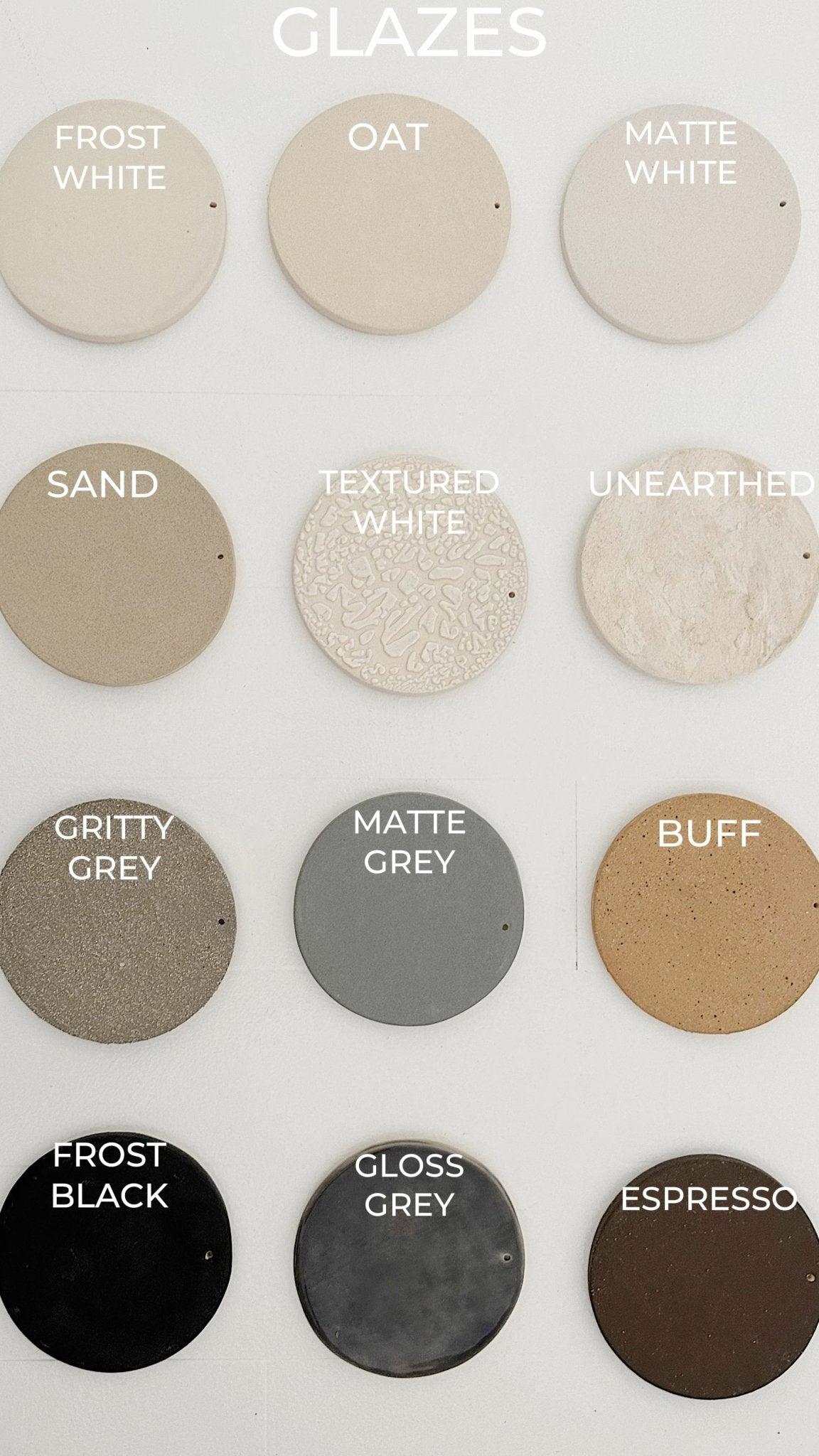 Coastal ceramic disc wall hanging on driftwood, styled in a modern interior