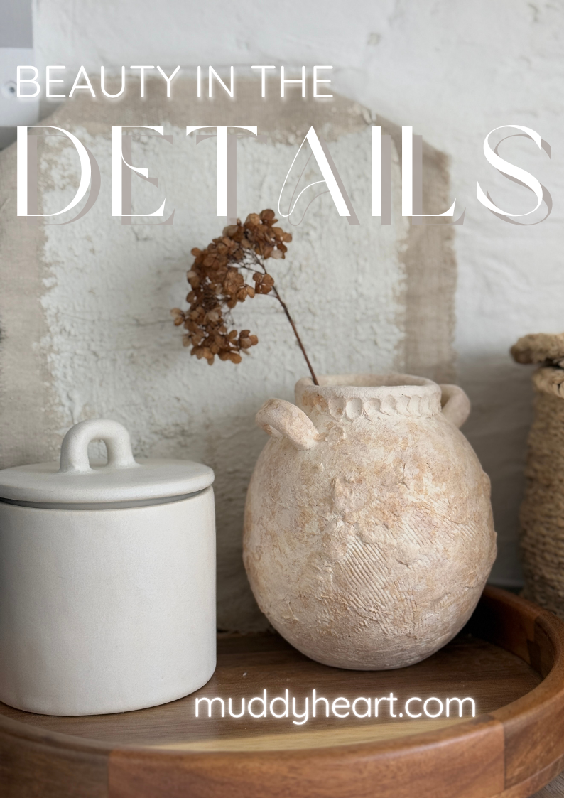 Textured wild clay handmade ceramic handled jar styled on a wooden tray with dried stems.