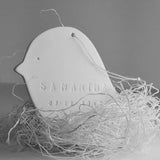 Personalized ceramic bird nest ornament, shown on holiday tree