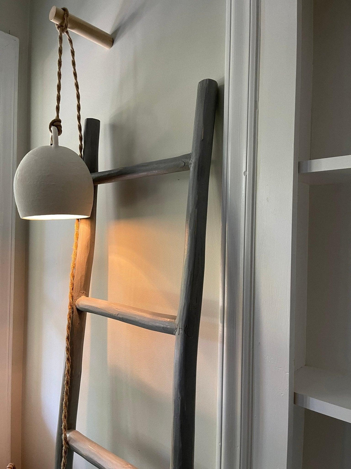 A handmade ceramic pendant lamp by Muddy Heart in warm light