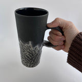 Handmade tall hand-carved ceramic mug in frosted black with a smokey-grey carved texture and glossy black interior