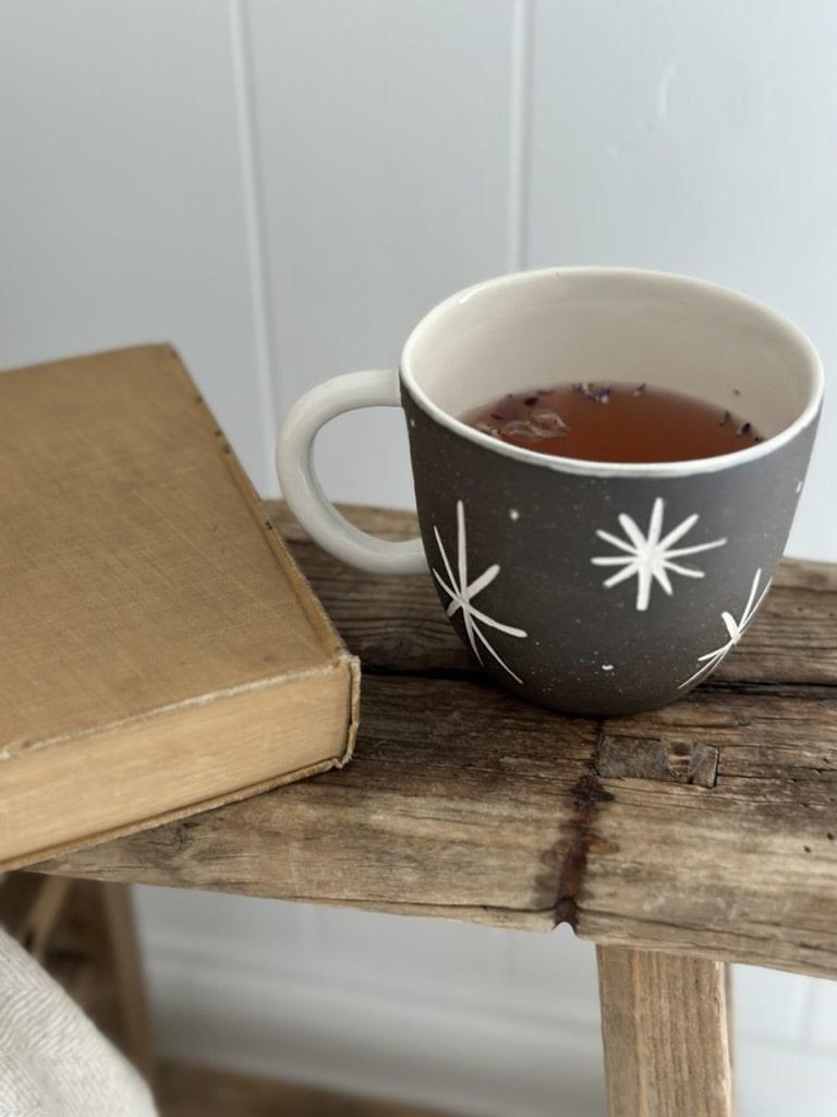 Handmade deep ceramic coffee mug with a carved star and stripe design