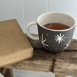 Handmade deep ceramic coffee mug with a carved star and stripe design