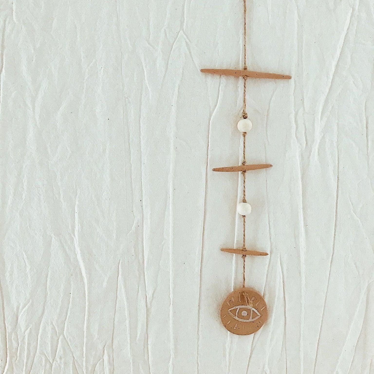 Handmade ceramic evil eye wall hanging in neutral tones by Muddy Heart