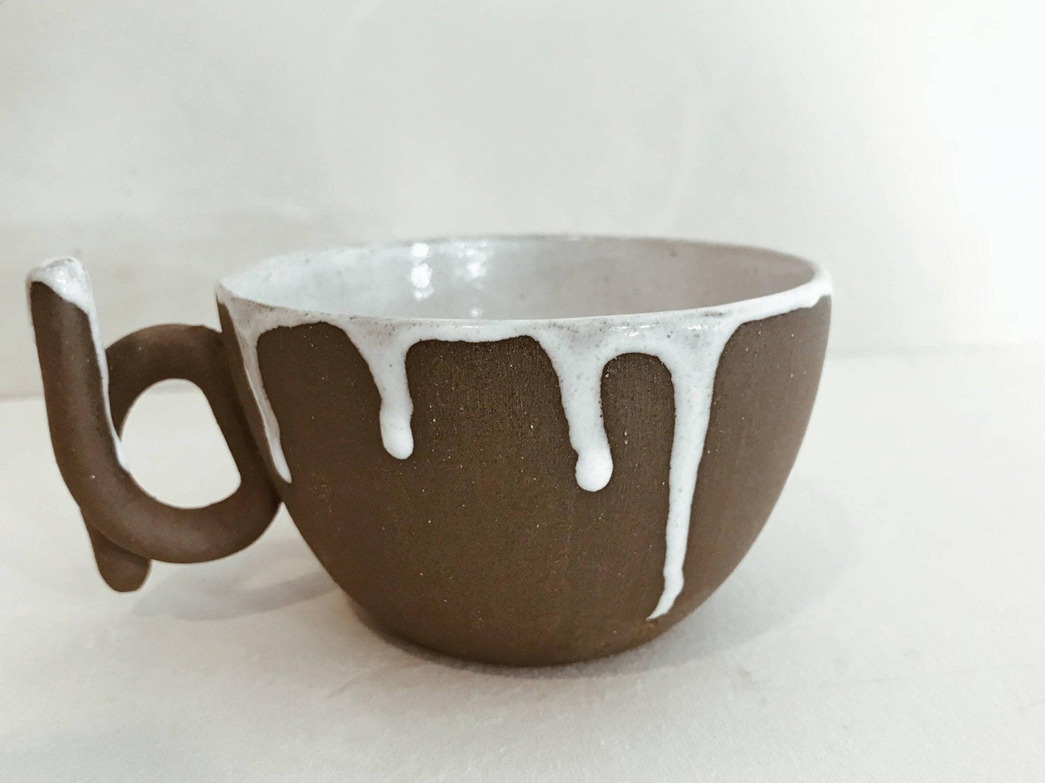Handmade ceramic mug with a loop handle and drip glaze