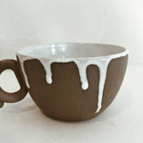Handmade ceramic mug with a loop handle and drip glaze