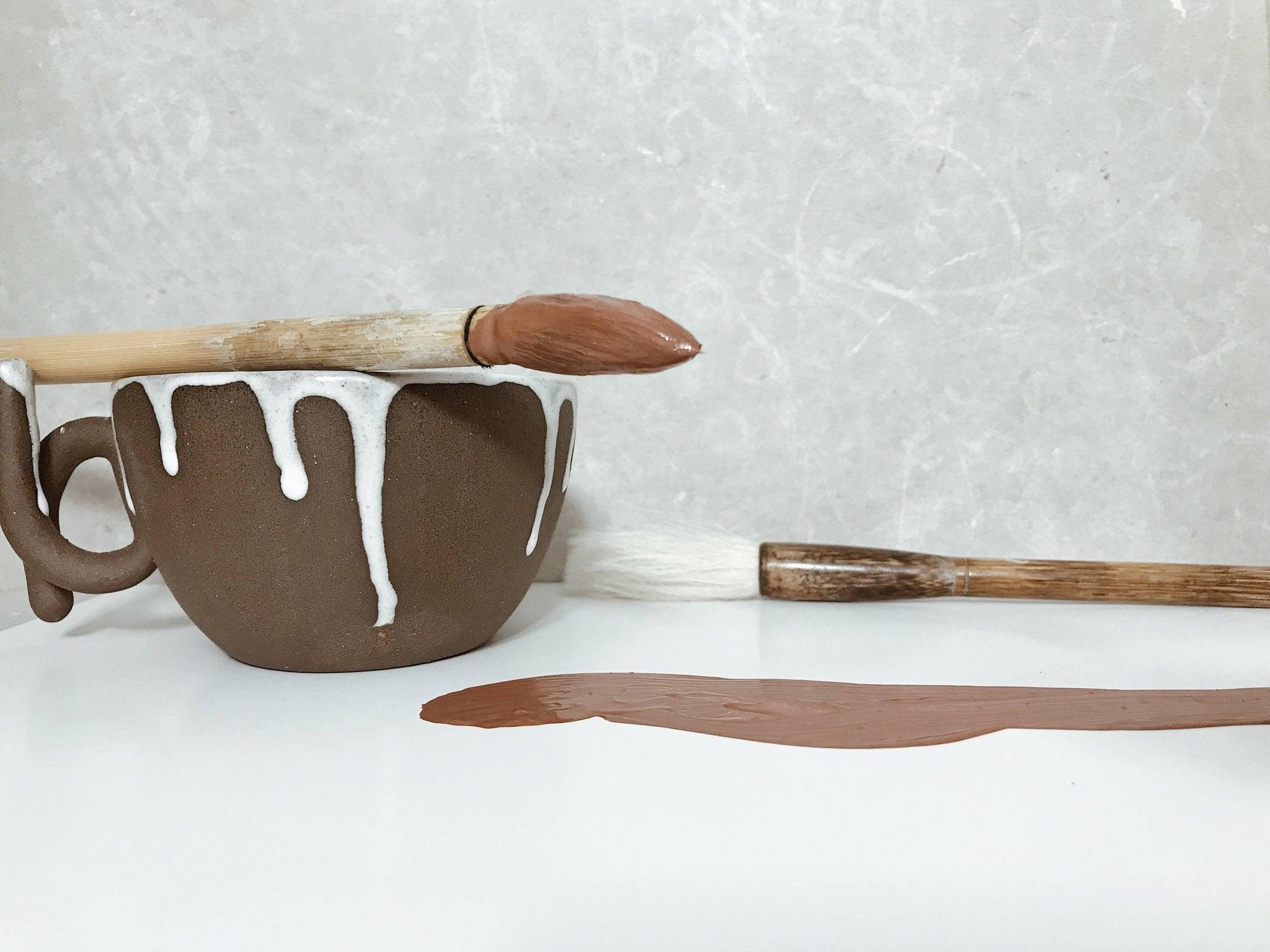 Handmade ceramic mug with a loop handle and drip glaze