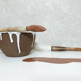 Handmade ceramic mug with a loop handle and drip glaze