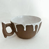 Handmade ceramic mug with a loop handle and drip glaze