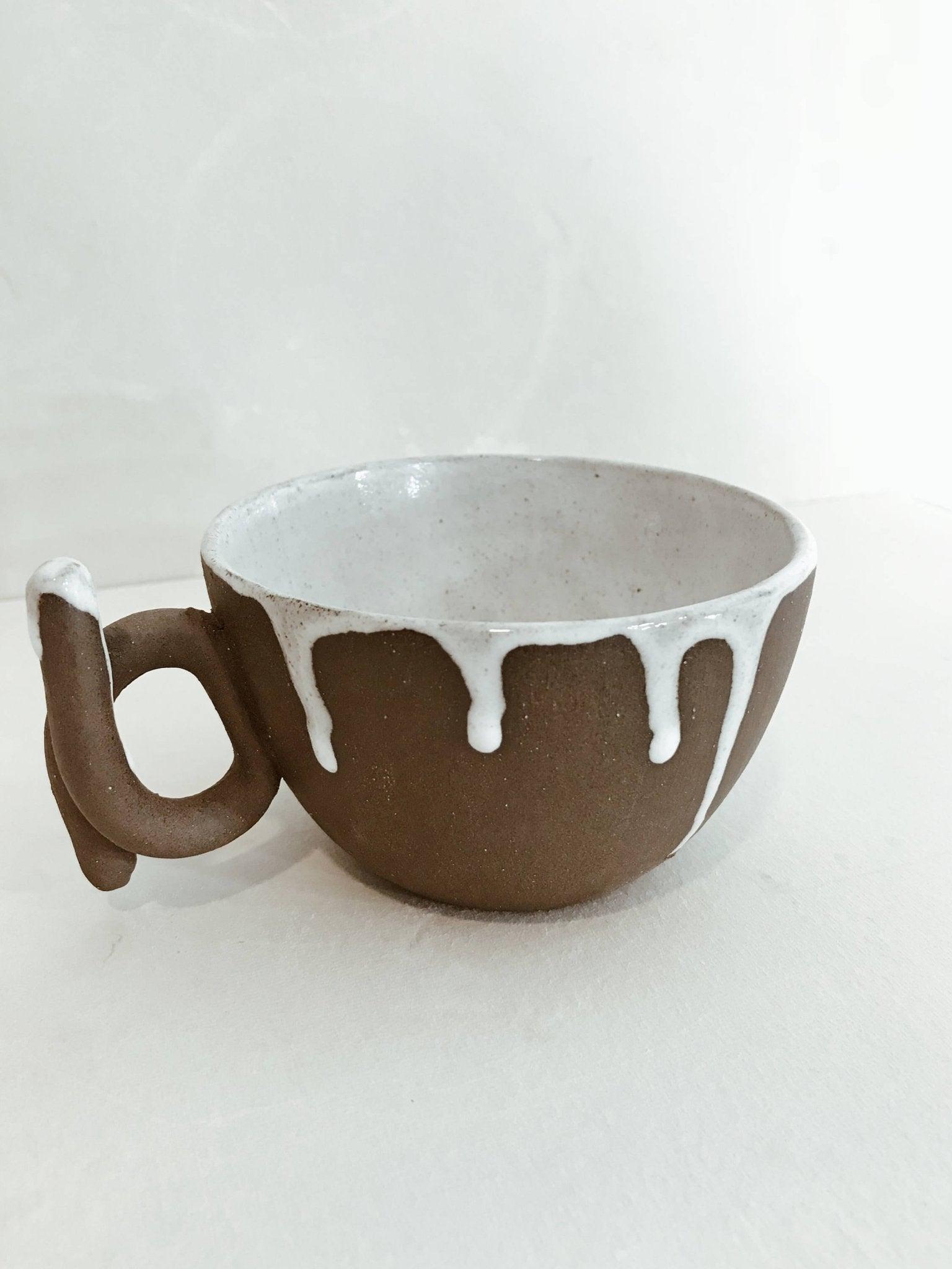 Handmade ceramic mug with a loop handle and drip glaze