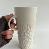 Handmade tall hand-carved ceramic mug in glossy white glaze