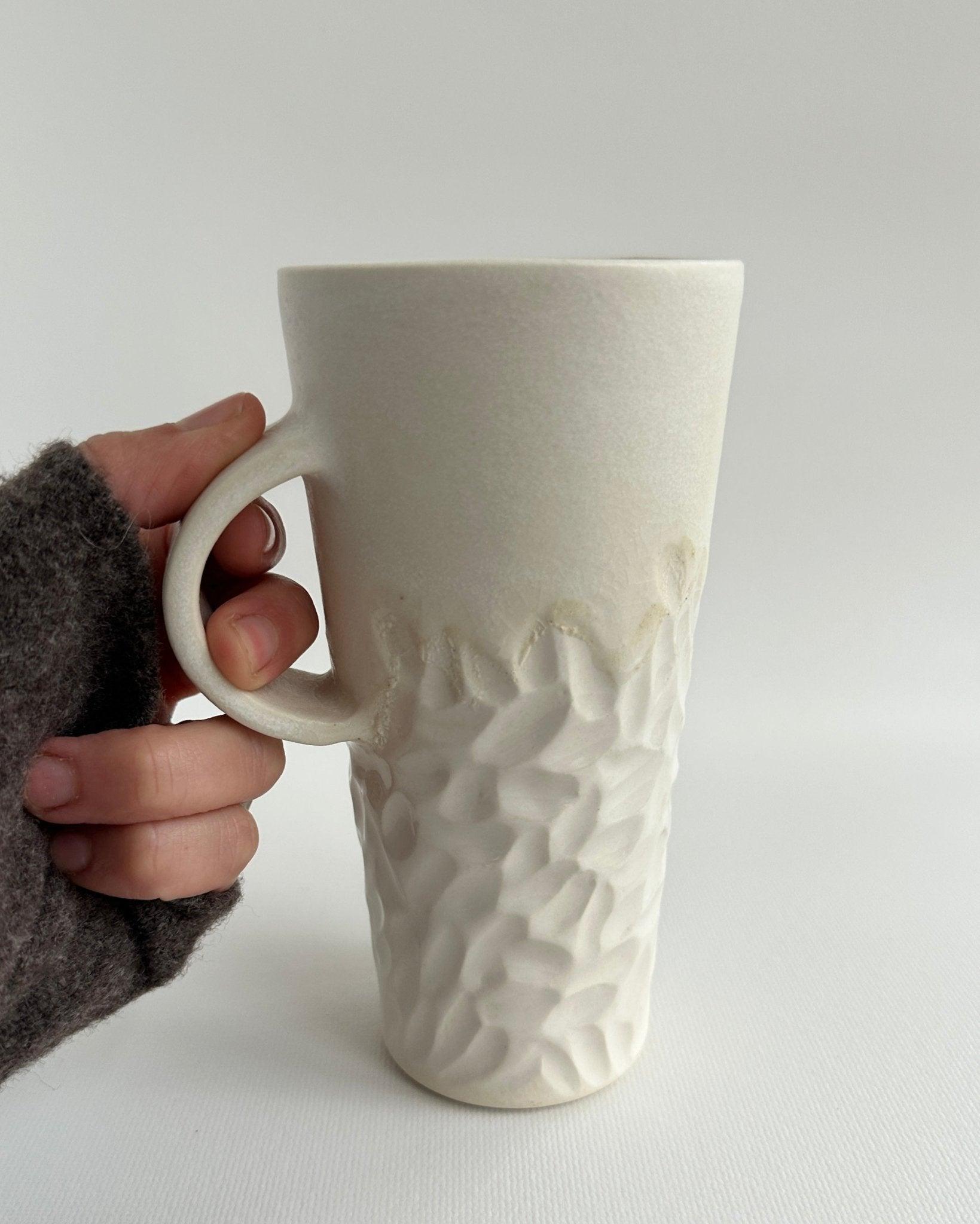 Handmade tall hand-carved ceramic mug in glossy white glaze