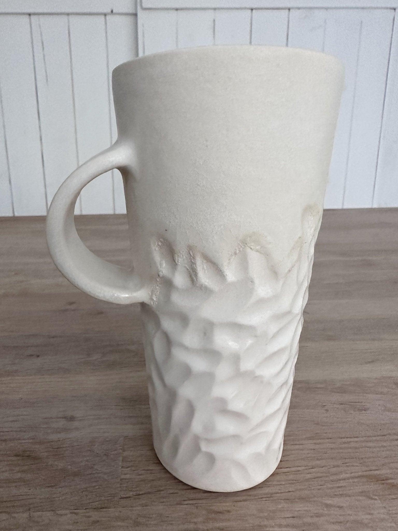 Handmade tall hand-carved ceramic mug in glossy white glaze