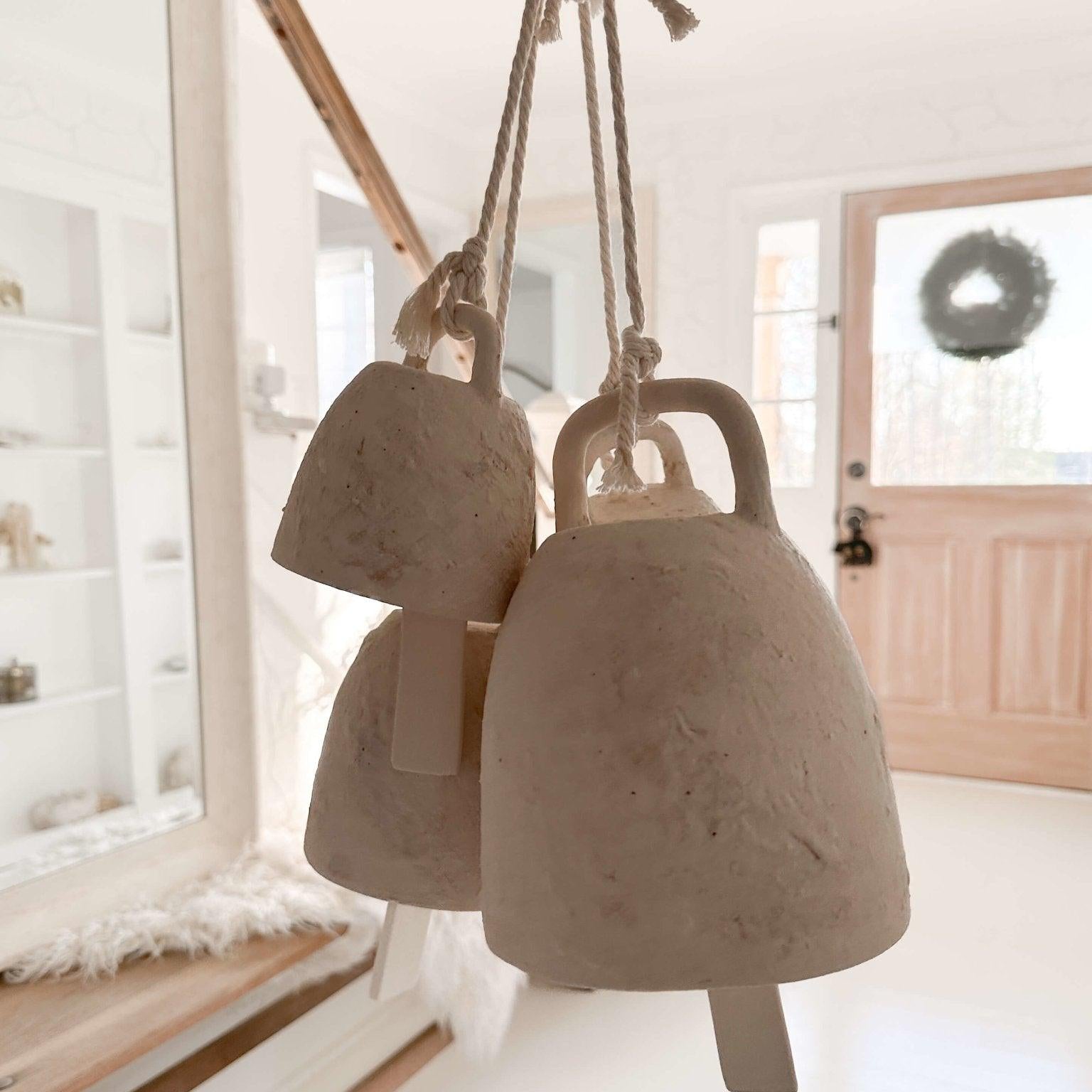 Handmade ceramic wish bell with a hanging cotton cord in a neutral glaze